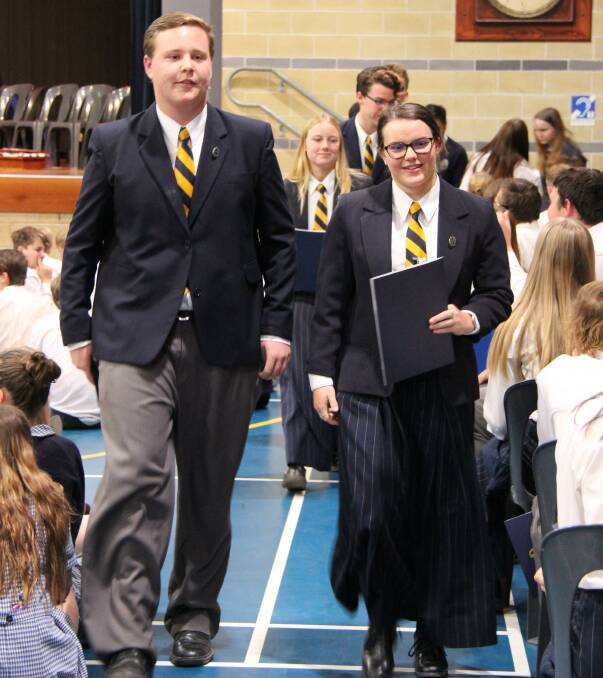 McCarthy captains Cameron Martin and Julia Hannaford lead their peers from the hall after their final assembly.