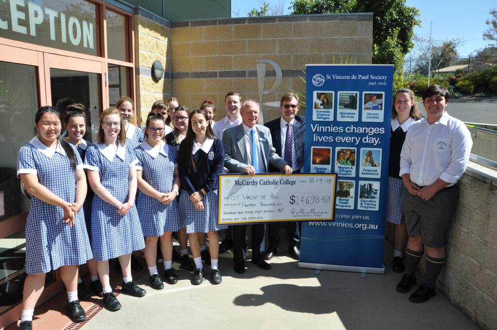 BIG CHEQUE: McCarthy Catholic College senior students and staff hand over the proceeds of their fundraising activities to St Vincent de Paul Society central council president Paul Burton.