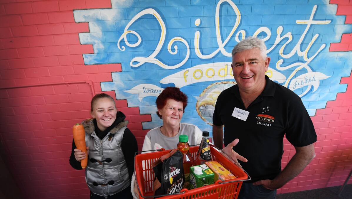CARING: Volunteers Alex Wilkes, Ally Riggs and James Ardill at Liberty Foodcare, which has been open for a year. Photo: Gareth Gardner 140618GGA002