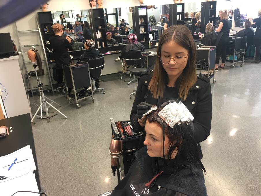 CONTEST: Hairdresser Jade McNeice, of Inverell, and model Tracy Lowings during the cut and colour section. 120819CMA01