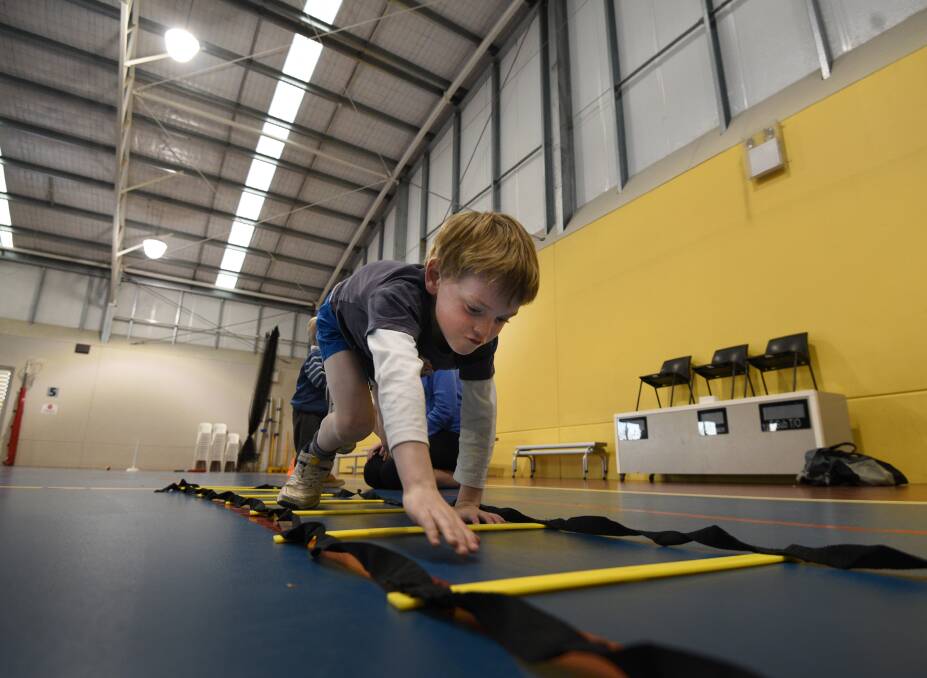 CHALLENGE: Joshua Filby, 6, tries out a modified climbing activity at the Wheels & Walkers sports group's official launch night. Photo: Gareth Gardner 150817GGC01