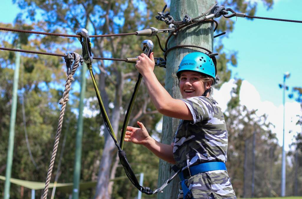 A participant takes part in a high ropes activity. The outdoor fun took place in settings much greener and with much more water than most of the young people live in.