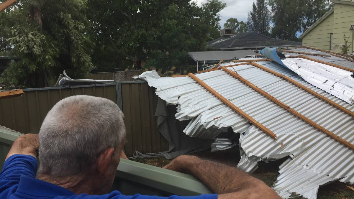 Tony Collins inspects the roof sheeting in next door's backyard.