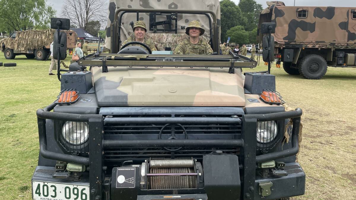 12/16 Hunter River Lancers troopers Felicity Lofts and Aaron Kemp behind the wheel of a bushmaster army vehicle at Curtis Park for the launch of the group's 75th anniversary.