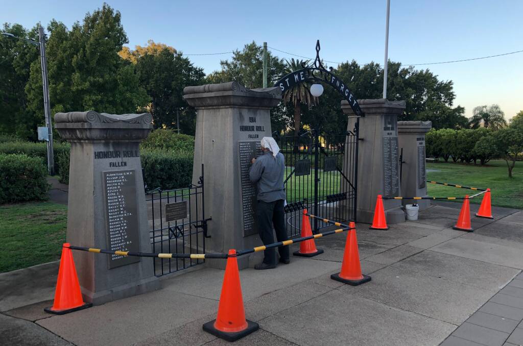 Chipping away: The Rookwood stonemason hard at work repairing damage to the Anzac Gates on Wednesday morning. Photo: Breanna Chillingworth