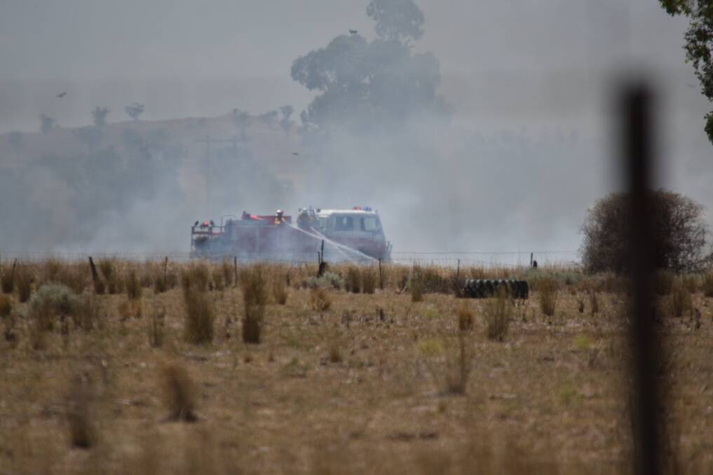Tough conditions: A Gunnedah RFS crew help mop up and contain a grass fire that broke out near Carroll just after midday on Saturday. Photo: Ben Jaffrey