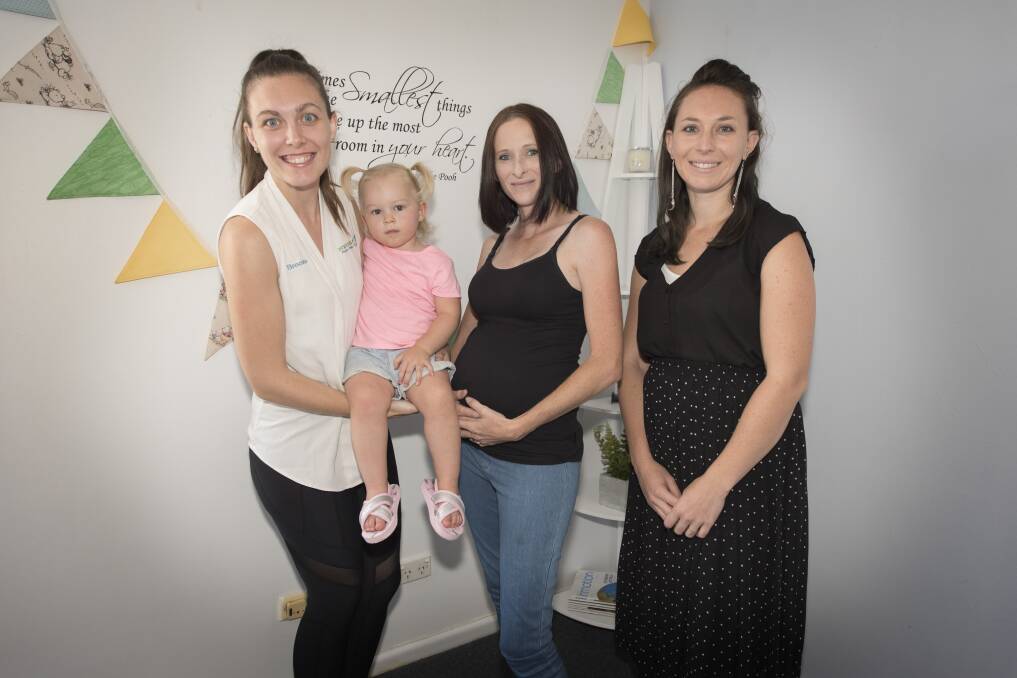 Mums and bubs: Pregnancy masseuse Brooke Carrington with Isabella Fitzgerald,
Ruth Fitzgerald and Kyra Howearth preparing for the maternity showcase. Photo: Peter Hardin 200319PHB016