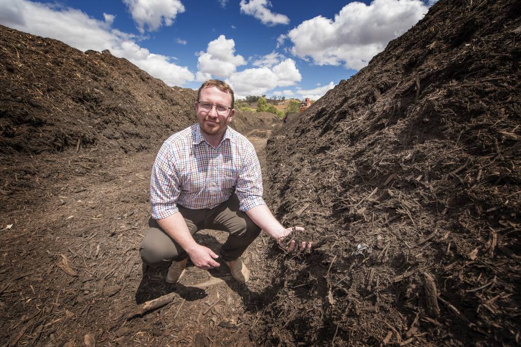 Dishing dirt: Council waste manager Dan Coe gets his hands dirty at the Tamworth green waste site which is already operating at capacity. Photo: Peter Hardin
