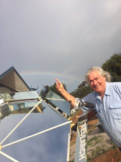 Peter Stevens points to a rainbow that he claims to have created with his Atmospheric Ionisation Research Machine in Western Australia.