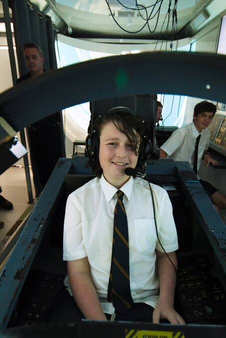 Hot shot: Alexander Budden sits in the cockpit of the RAAF F/A18 Super Hornet fighter jet simulator at Oxley High School on Friday. Photo: Gareth Gardner 031117