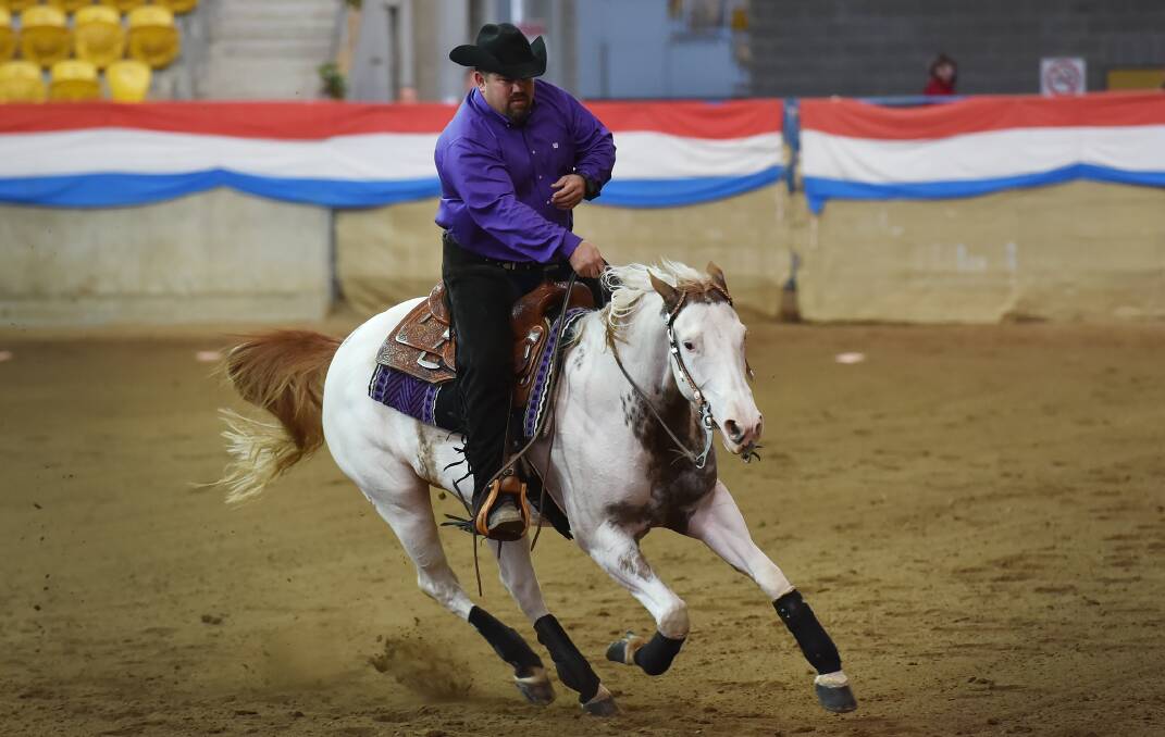 Reins down: Shane Sainsberry has his white steed flying around circles in the pattern during the Non Pro at the Gold Buckle Reining Futurity.
