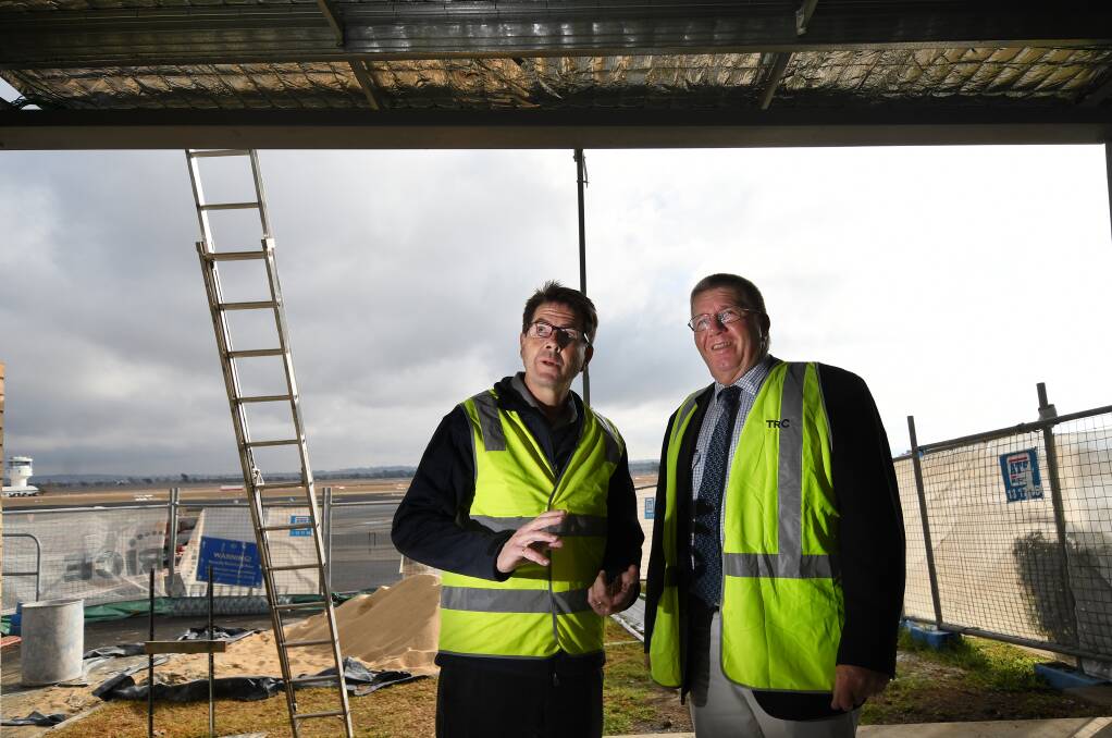 Flying towards 100,000: Kevin Anderson and Mayor Col Murray take a look at how the $6 million Tamworth Airport terminal upgrade is coming along with stage one to be opened at the end of July. Photo: Gareth Gardner