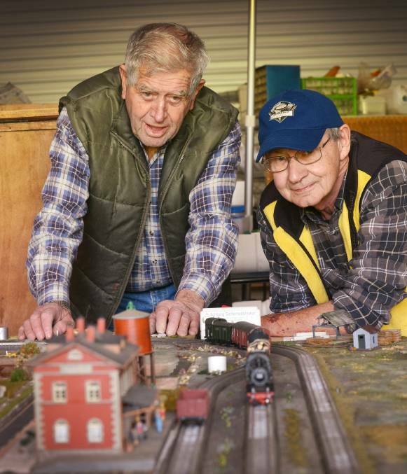 All aboard: Les Taylor and David Greenland tinker with the electric model train set that first attracted the new president to the Shed in 2016.