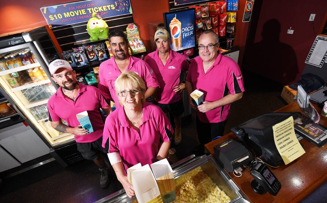 Pink popcorn: Local tradies Blake Saban, Gary Sinclair and Rod Watt get behind the counter with Forum Six Cinema staff Grant Lee and Kerry Partridge as the pink brigade spreads across the state. Photo: Gareth Gardner