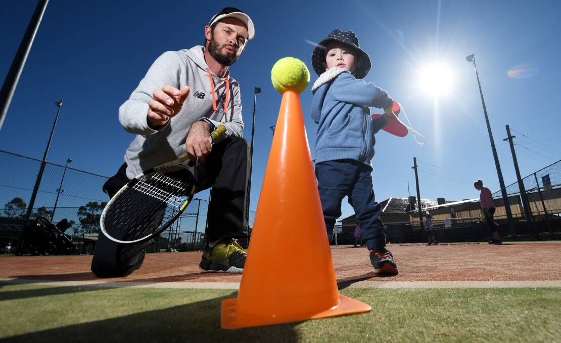 Big swing: Mitch Power gives young gun Harry Crowe some top tips as the coach prepares to launch a tennis program for Tamworth toddlers. Photo: Gareth Gardner 