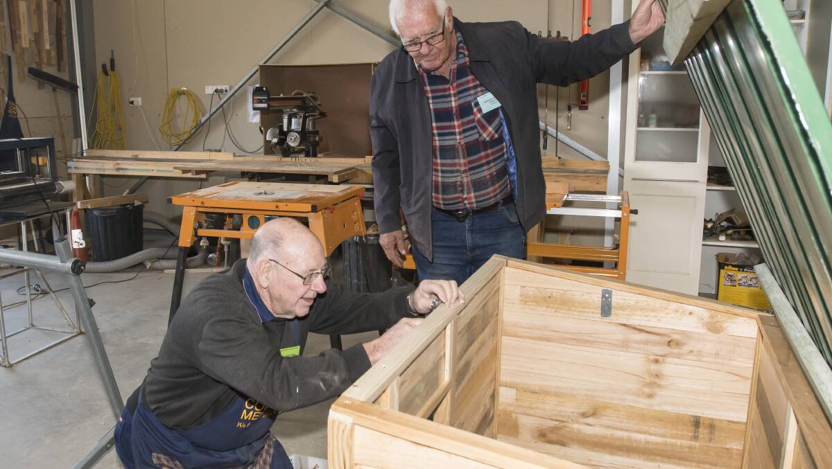 People passion: Les Thurkettle and Kerry Edmonds put the finishing touches on a dog kennel made out of wooden pallets for the Heaven Can Wait shelter. Photo: Peter Hardin