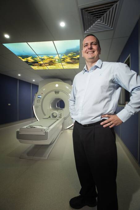 Not so mean machine: Michael Fawcett stands in front of the brand new MRI machine that is just one of four in the Asia Pacific region. Photo: Peter Hardin 080317