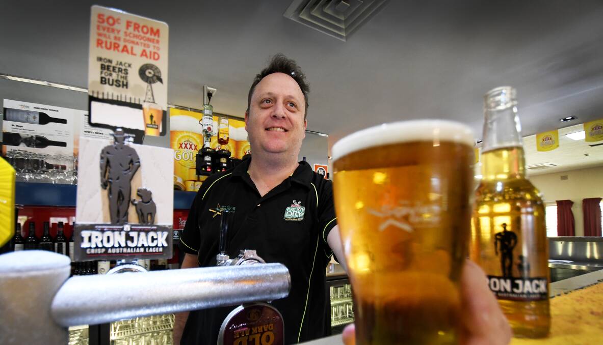 Thirsty work: North Bowlo manager Chris Clarke helps a patron chip in for farmers with a campaign set to raise $1 million for Rural aid. Photo: Gareth Gardner