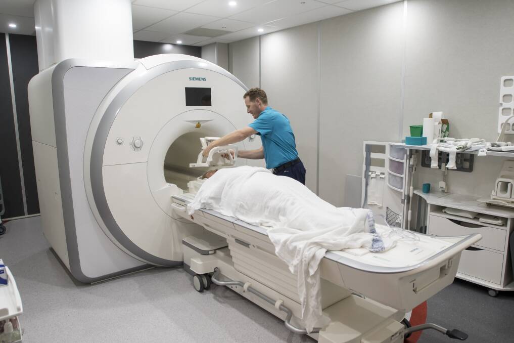 Safer service: Radiographer Adam Loveday prepares a patient for the new MRI machine. Photo: Peter Hardin