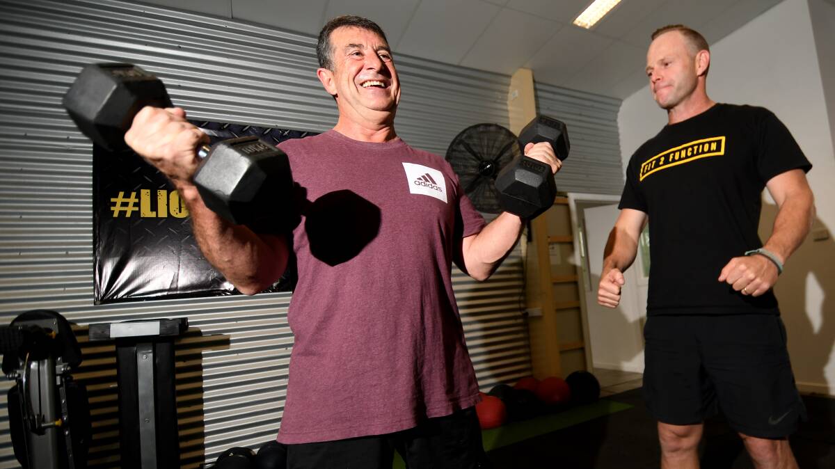 No excuse: Greg Blanch pumps iron with trainer Brady Walker, who backs the sentiment 'anything is better than nothing'. Photo: Gareth Gardner