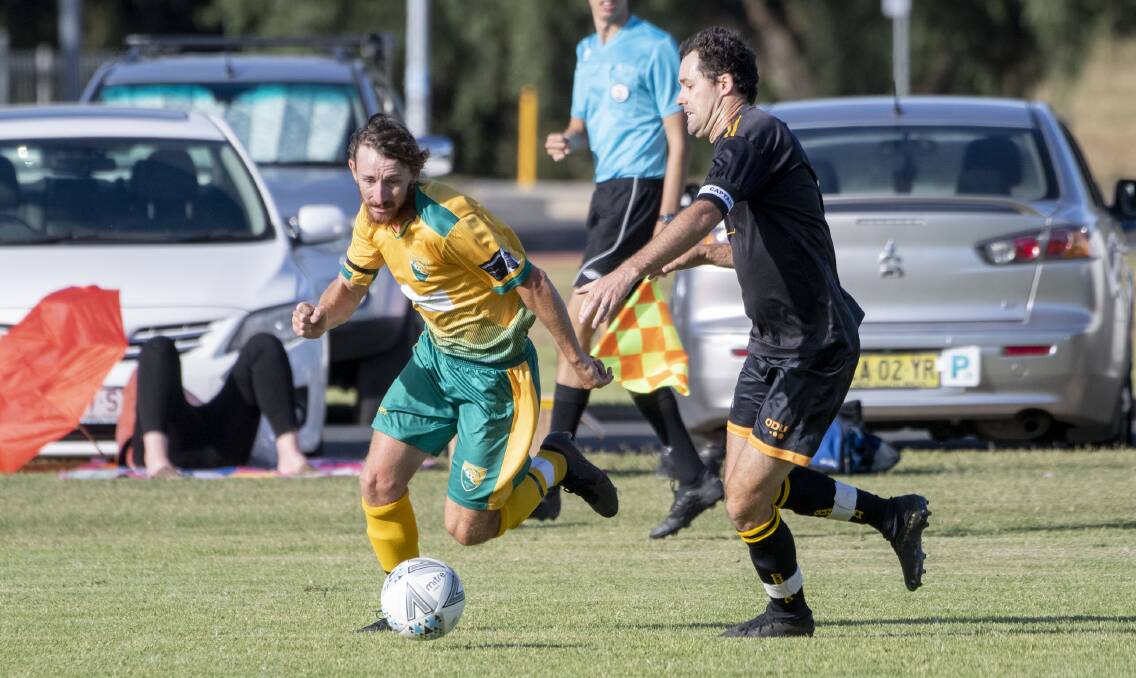 DEFENCE: David Silver wears the captain's armband of the black strip of Gunnedah FC against South United last weekend. Photo: Peter Hardin