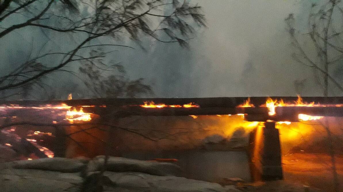 The bridge leading into Wytaliba burns. Emrgency services created a sidetrack to get across the creek on Saturday.