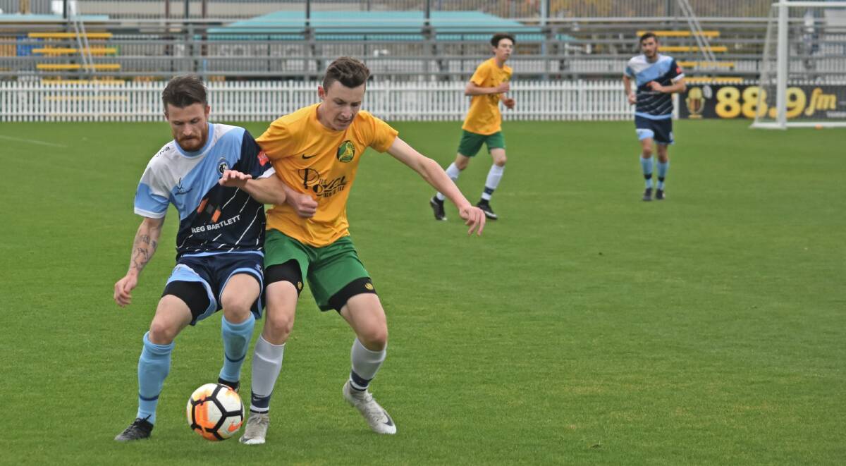 Tamworth FC's Jackson Haussler and South Armidale's Liam Northam fight for possession during a match in June. Picture: Ben Jaffrey