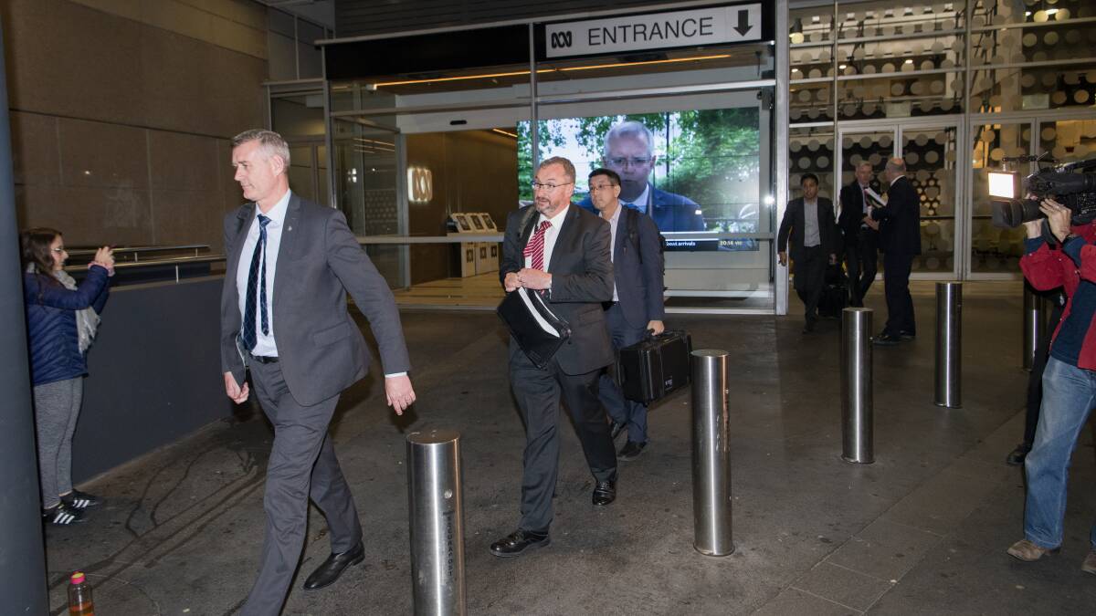 AFP depart the ABC studios after raiding them for information. Picture: Wolter Peeters