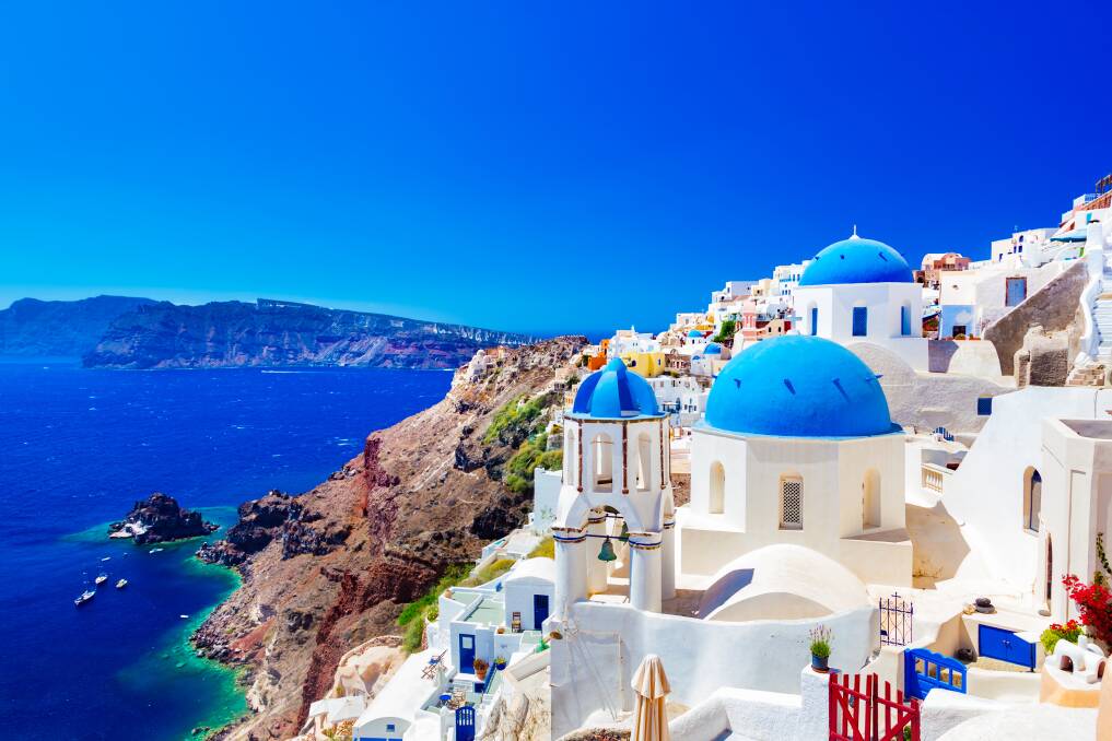 Oia town on Santorini island, Greece. Get amongst the traditional and famous houses and churches with blue domes over the Caldera, Aegean sea.