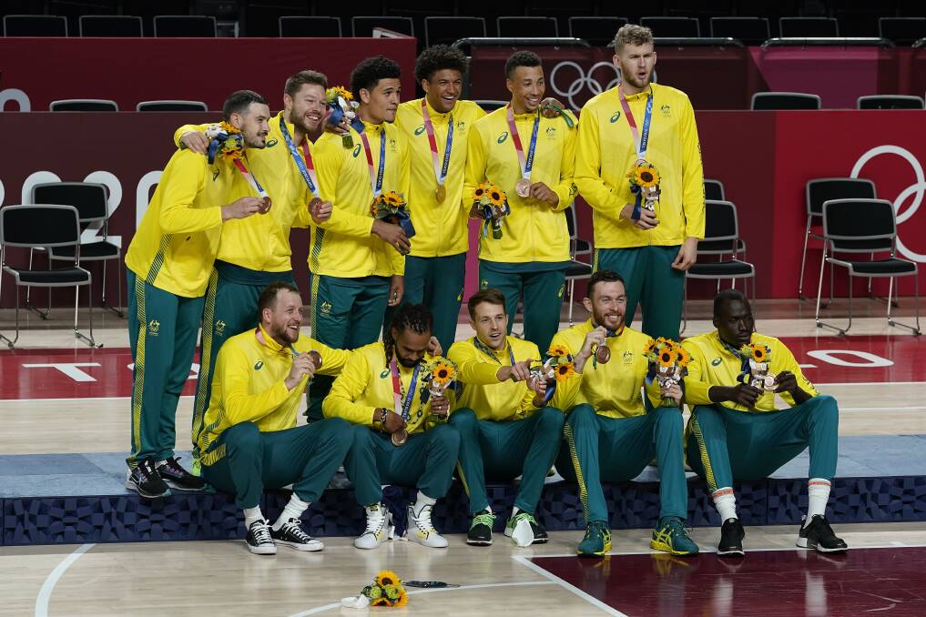 BUZZING: Nick Kay (sitting, second right) and the Boomers after winning bronze at Tokyo. Photo: AP