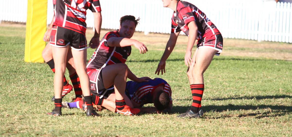 STRICKEN: North Tamworth prop James Cooper calls for assistance for Bulldogs halfback Matt Brady after he was hammered by Bears prop Shane Wadwell.