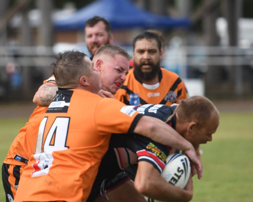 PACK ATTACK: The Tigers wrangle with Kyle Cochrane at Manilla Showground. Photo: Mark Bode