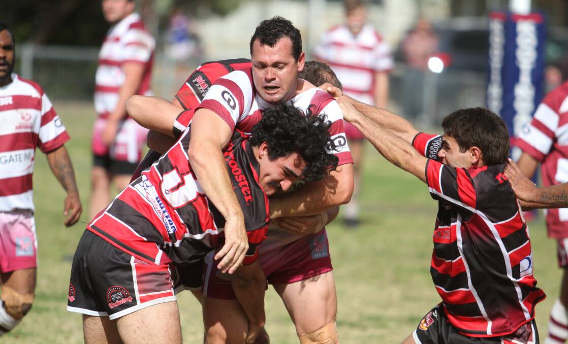 ROBIN TRAPPED: South West captain-coach Shane Howarth hits a North Tamworth brick wall led by centre Tyrone McRodden. 