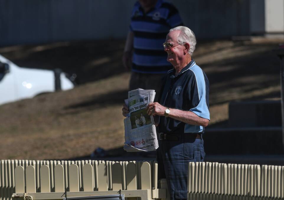 HOW SWEET IT IS: John Kilborn, a Souths life member with legend status at the club, holds The Leader's grand final back page. The headline reads: Tom's 'too good'. 