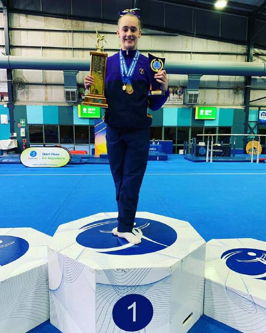 PROUD AS PUNCH: Tamworth's Josie Douglas celebrates her overall win in level eight at the NSW country gymnastics championships at Lismore. Photo: Facebook