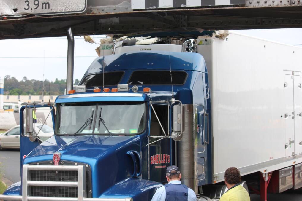 STUCK: A Queensland freight truck en route to Big W became jammed in the McLennan St viaduct on Thursday.
