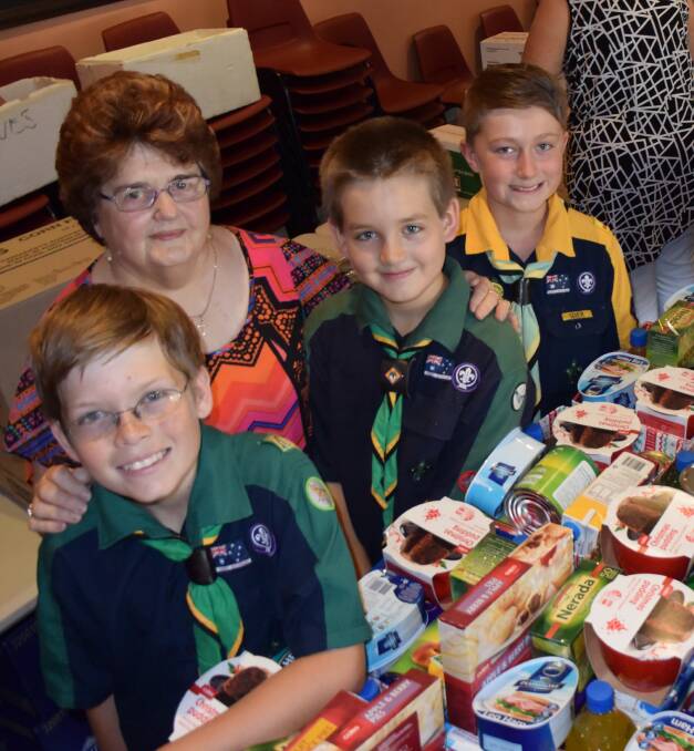 HELPING HAND: James Harrison, 11, Edna Sheppeard, Tom Didlick, 11, and Daniel Moore, 10, help pack hampers for Uniting Care's 25th Christmas Appeal. 