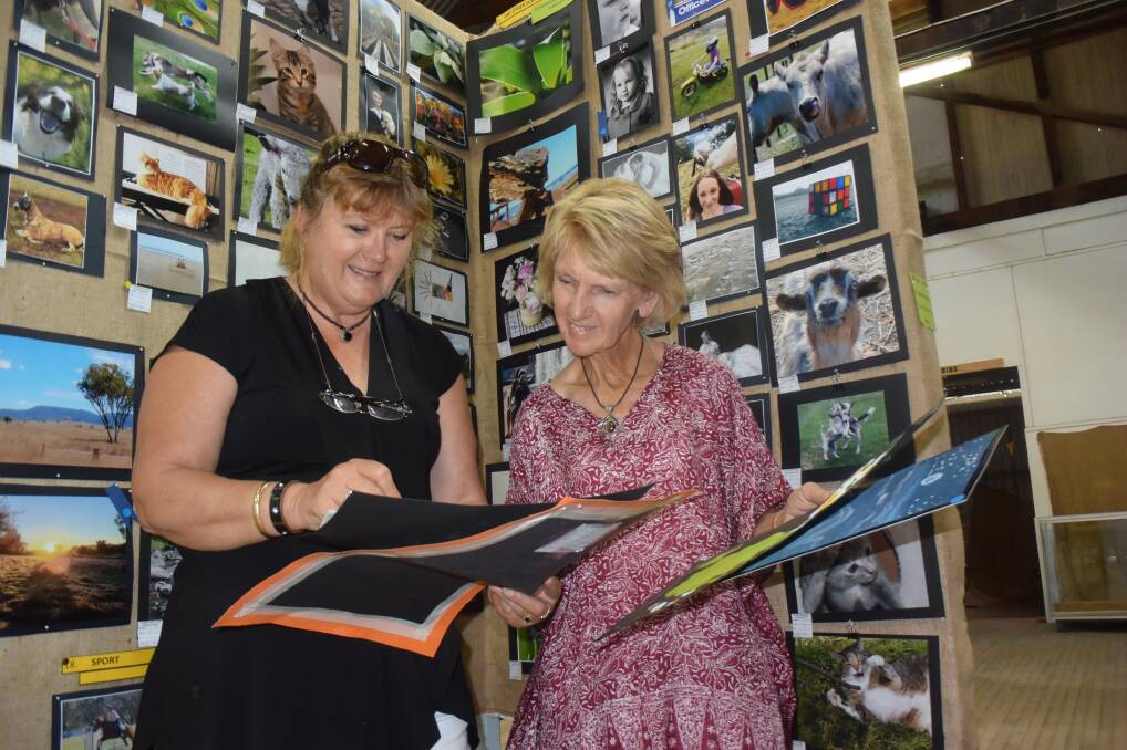 MASTERPIECES: Pavillion judge Sue Burchell and chief steward Janelle Tongue look over some of the artwork submitted in this year's Tamworth Show. Photo: Ella Smith 
