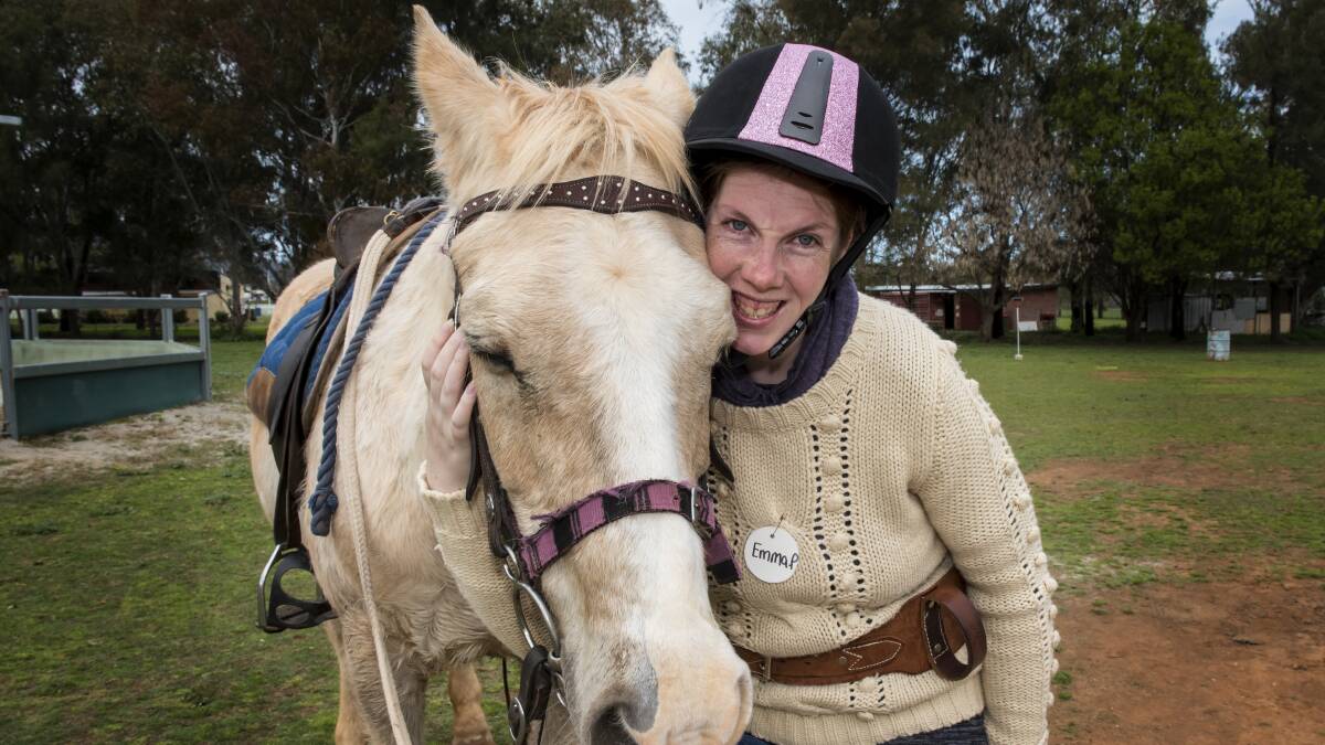 SPECIAL BOND: Emma Plowman cuddles up to Icecream at a Riding for the Disabled day in Tamworth. Photo: Peter Hardin 010916PHB04