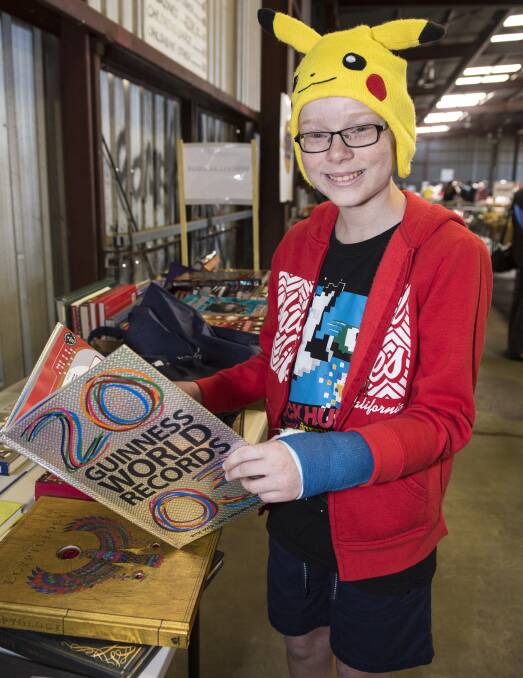 BOOK WORM: Connor Clifton scrubs up on some records while wandering through the Lions Club book fair on the weekend. Photo: Peter Hardin 151016PHB024