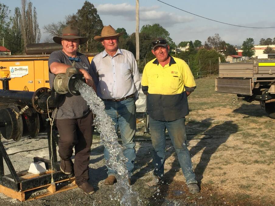 Tenterfield Shire Council chief executive Terry Dodds and Mayor Peter Petty with Michael Wilson of Water Resources Drilling, Dubbo, grinning at the water flow that will relieve the town of its crisis.