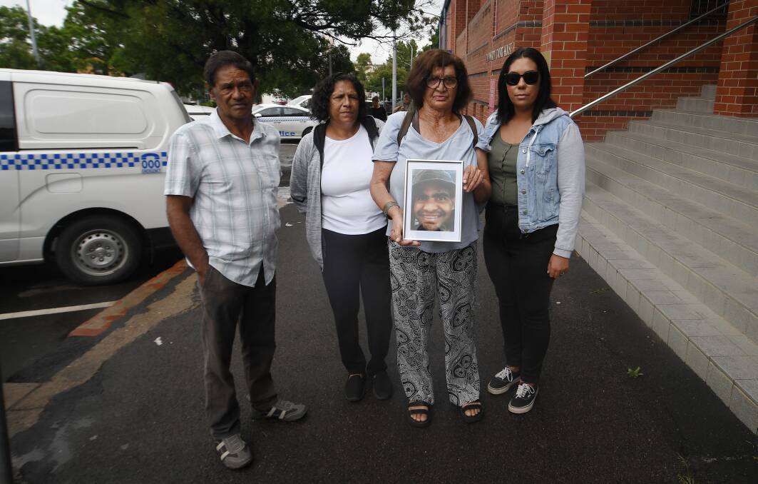 William Haines' family members hold a photo of him, which they granted permission to publish, outside court. Picture by Gareth Gardner