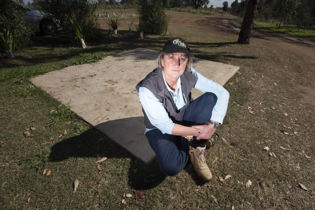 HARD WORK UNDONE: OzFish's Anne Michie at the empty concrete slab where a flood-proof table was bolted down before it was stolen. Photo: Peter Hardin 