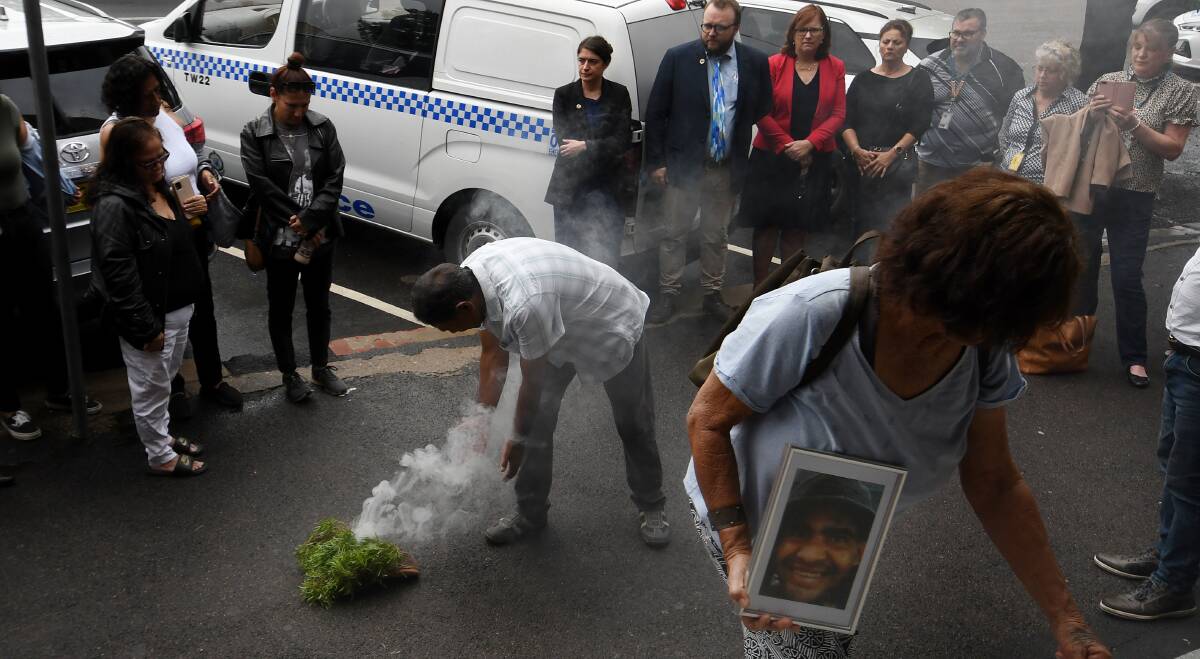 William Haines' family carry a photo of him, which has been published with their permission, into the Tamworth courthouse for the inquest's opening day after a traditional smoking ceremony. Picture by Gareth Gardner