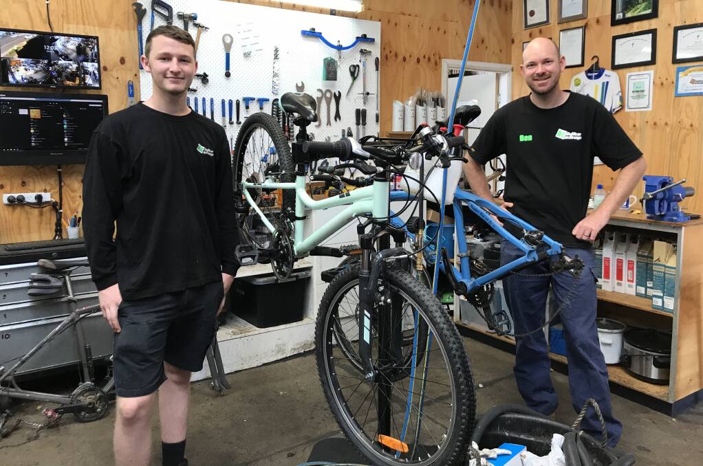 REPAIRING RIDES: Matthew Mackay and Ben Clark from BC Bike Shop are busy fixing up bikes for locals. Photo: Anna Falkenmire