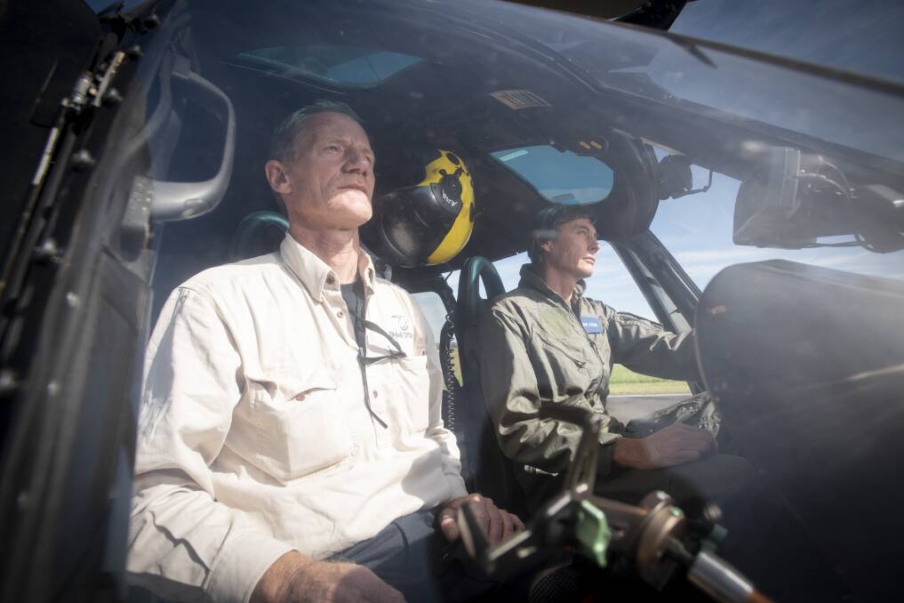 MISSION: Ken Jakobi and Dan Cross prepare the helicopter for a 7-hour flight around the Tamworth, Gunnedah and Coonamble areas. Photo: Peter Hardin