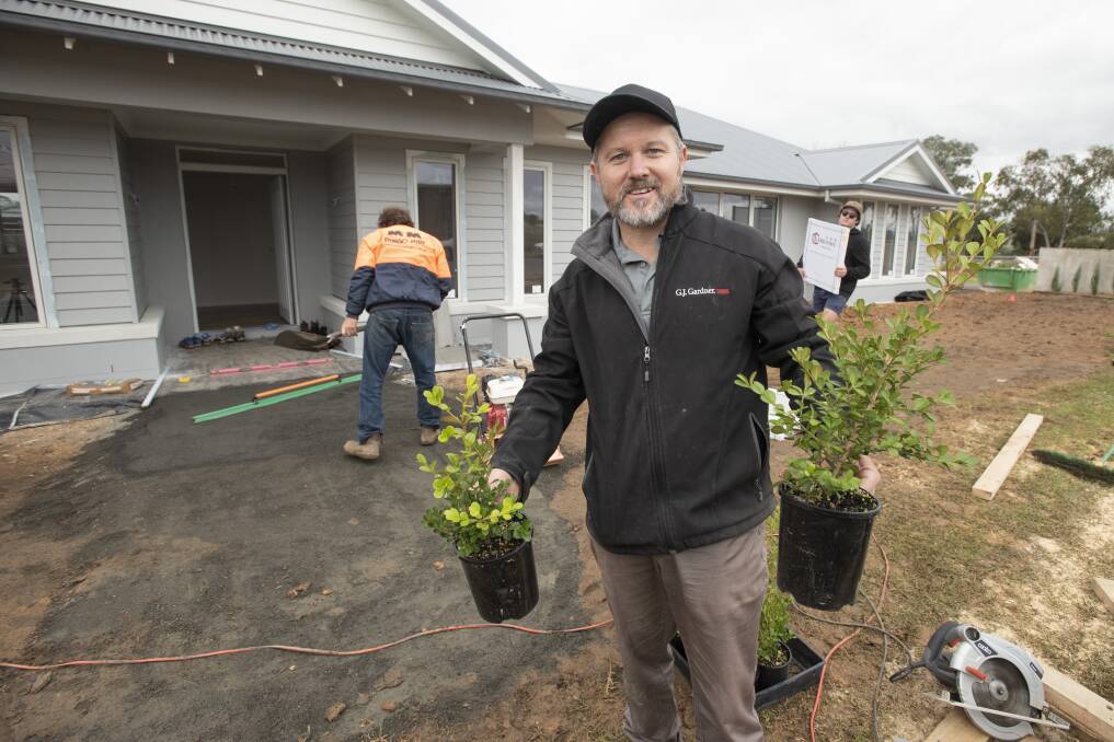 Daniel Urquhart mucking in with landscaping at the House that Drought Built. Photo: Peter Hardin 