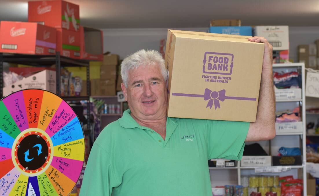 HELPING HAND: Liberty Church Senior Pastor James Ardill shows off a Christmas food hamper on offer at their not-for-profit grocery. Photo: Andrew Messenger