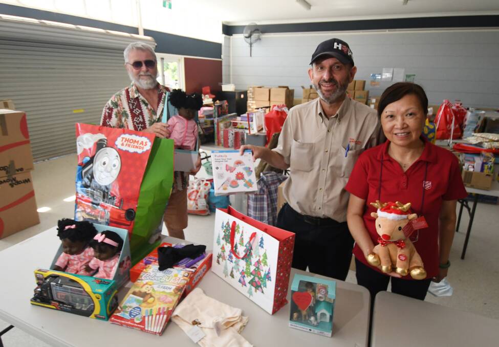 TIME FOR GIVING: Bruce McCorkell from the Rotary Club of Tamworth handed over a donation of Christmas presents on Friday to Salvation Army Majors Tony and Yan DeTomasso. Photo: Gareth Gardner
