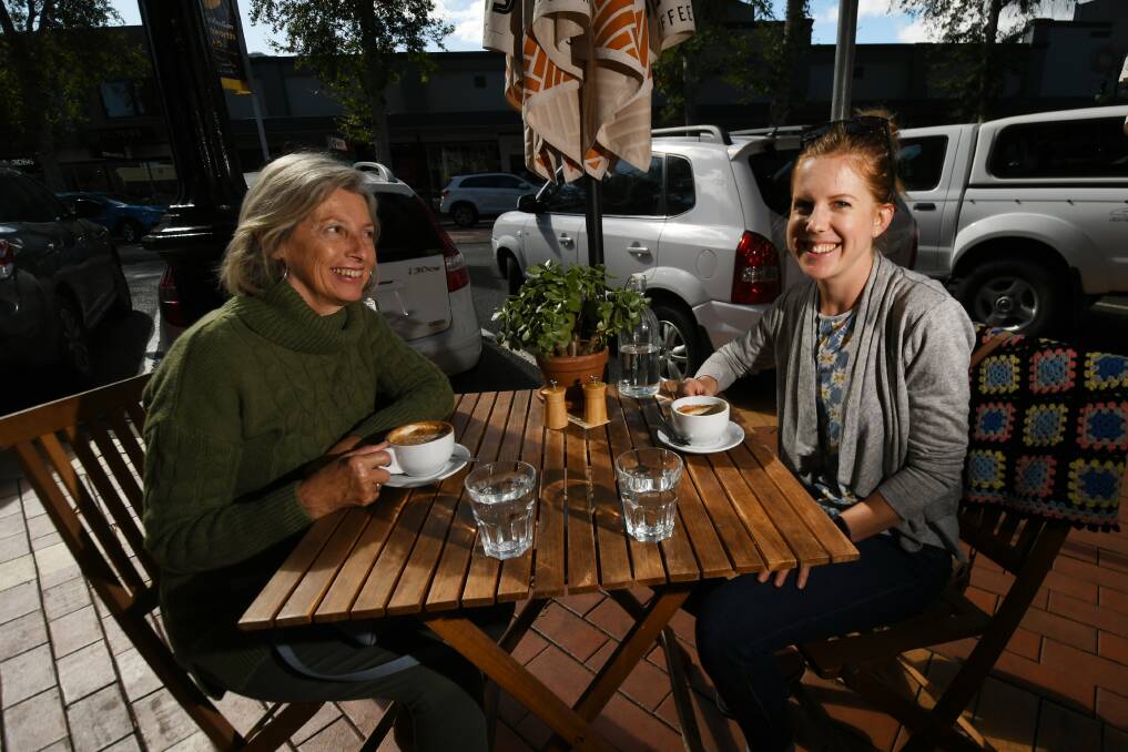 New normal: Jessica Hays and Carolyn Connor enjoy a cup of coffee - sitting down - at Hissy Fits Cafe in Tamworth's Peel Street. Restrictions on dine-in meals lifted for the first time on Friday. Photo: Gareth Gardiner